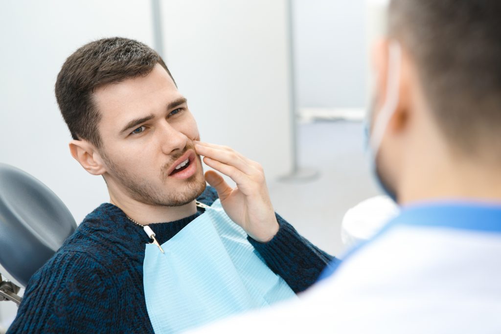 man in mouth pain at the dentist
