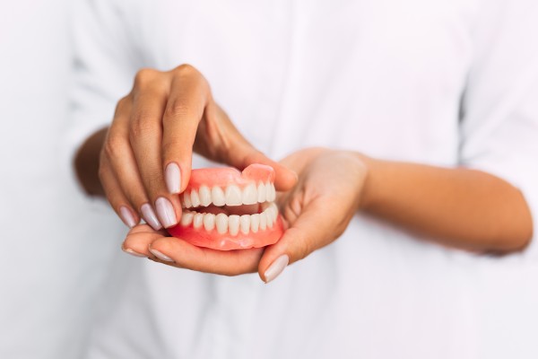 a woman holds dentures