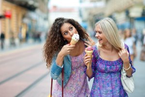 A girl comfortably eats ice cream after getting a tooth-colored filling.